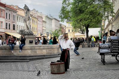 Чеканщик в национальной одежде на площади Рынок